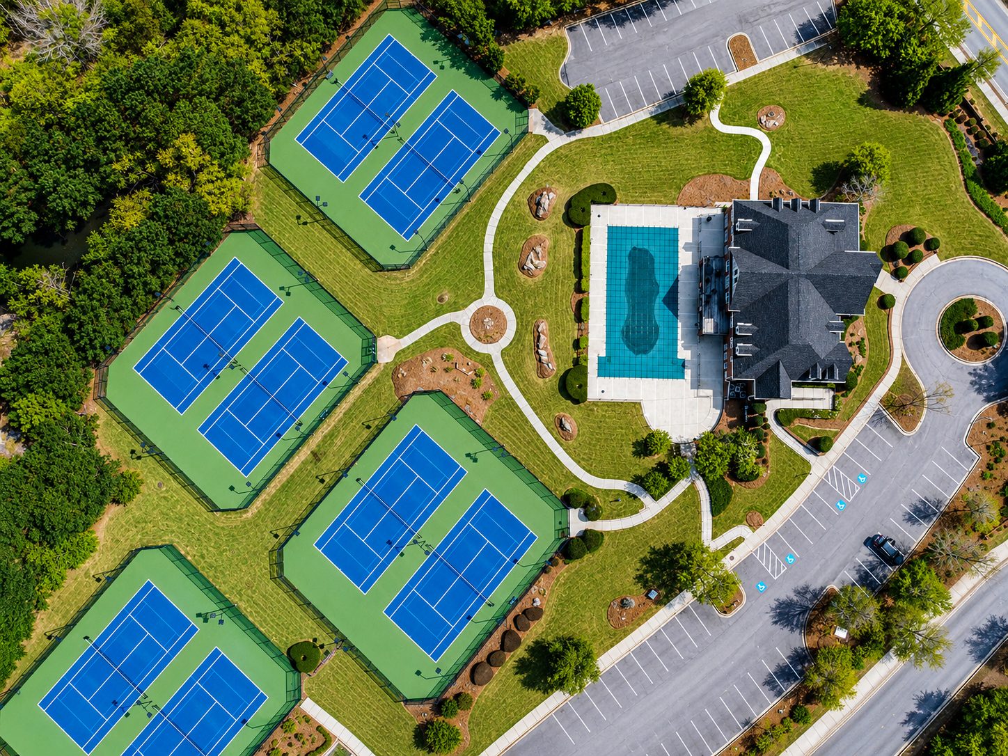 Aerial of community amenities — tennis courts, pool, and clubhouse